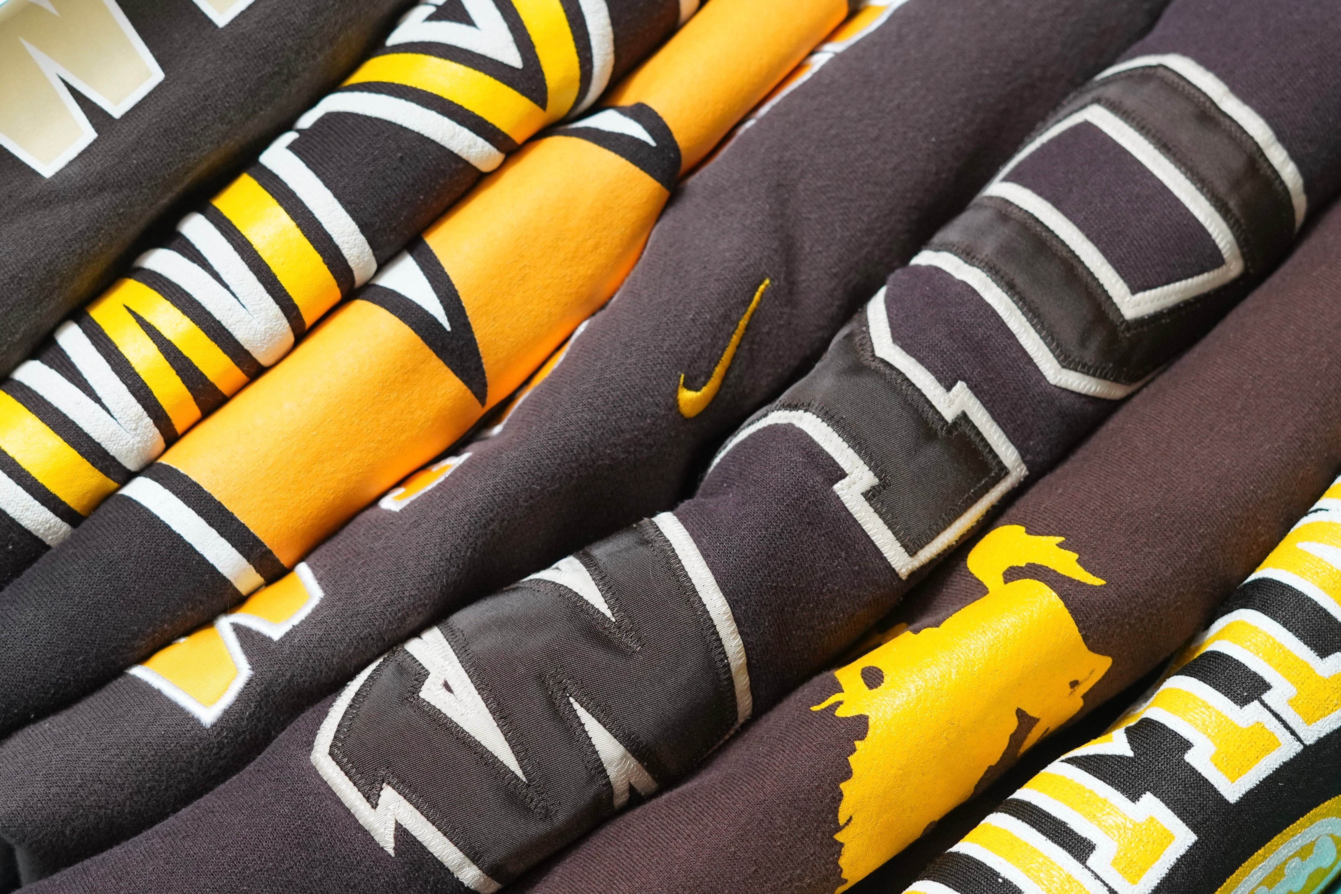 Stack of vintage University of Wyoming sweatshirts in brown and gold featuring retro logos and Nike detailing — authentic Wyoming Cowboys apparel from West Block Vintage.