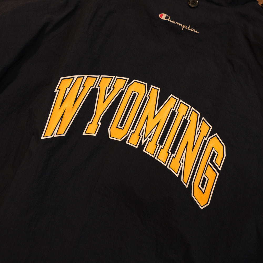Detail of large gold Wyoming lettering and Champion embroidery on vintage navy warm-up jacket