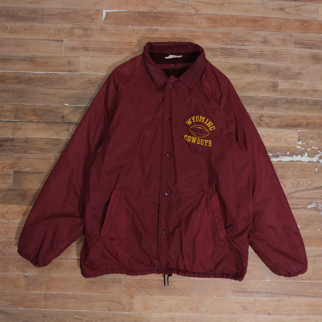 Burgundy 1970s Champion Wyoming Cowboys sideline jacket with yellow football chest print and snap-button closure