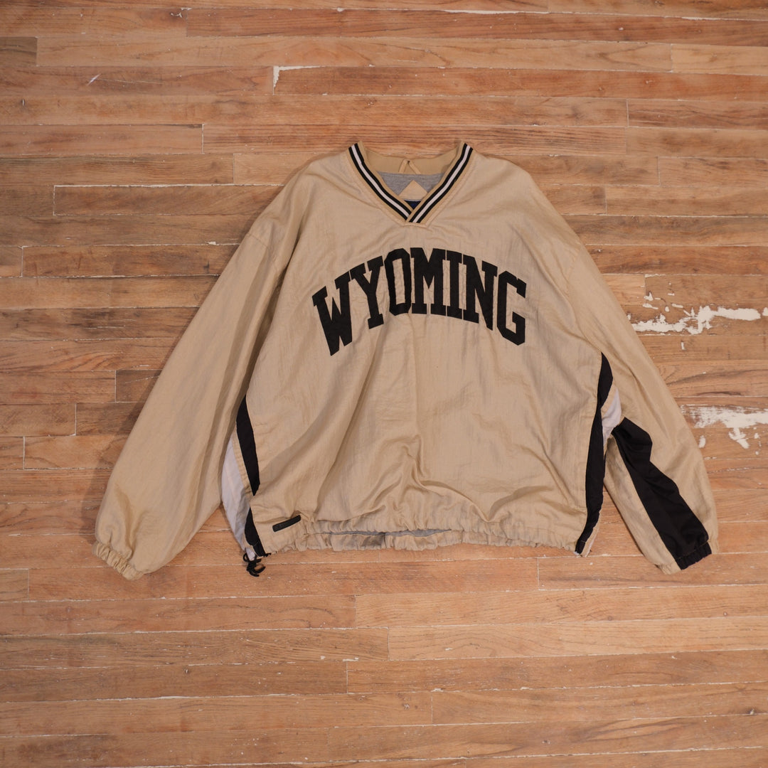 Cream 1990s Wyoming Cowboys V-neck windbreaker with black Wyoming lettering and striped collar