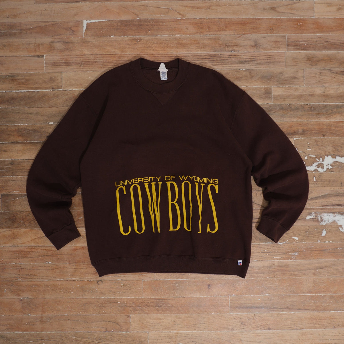 1980s brown / gold 80s University of Wyoming Cowboys Brown Gold Print Crewneck photographed flat on wood floor
