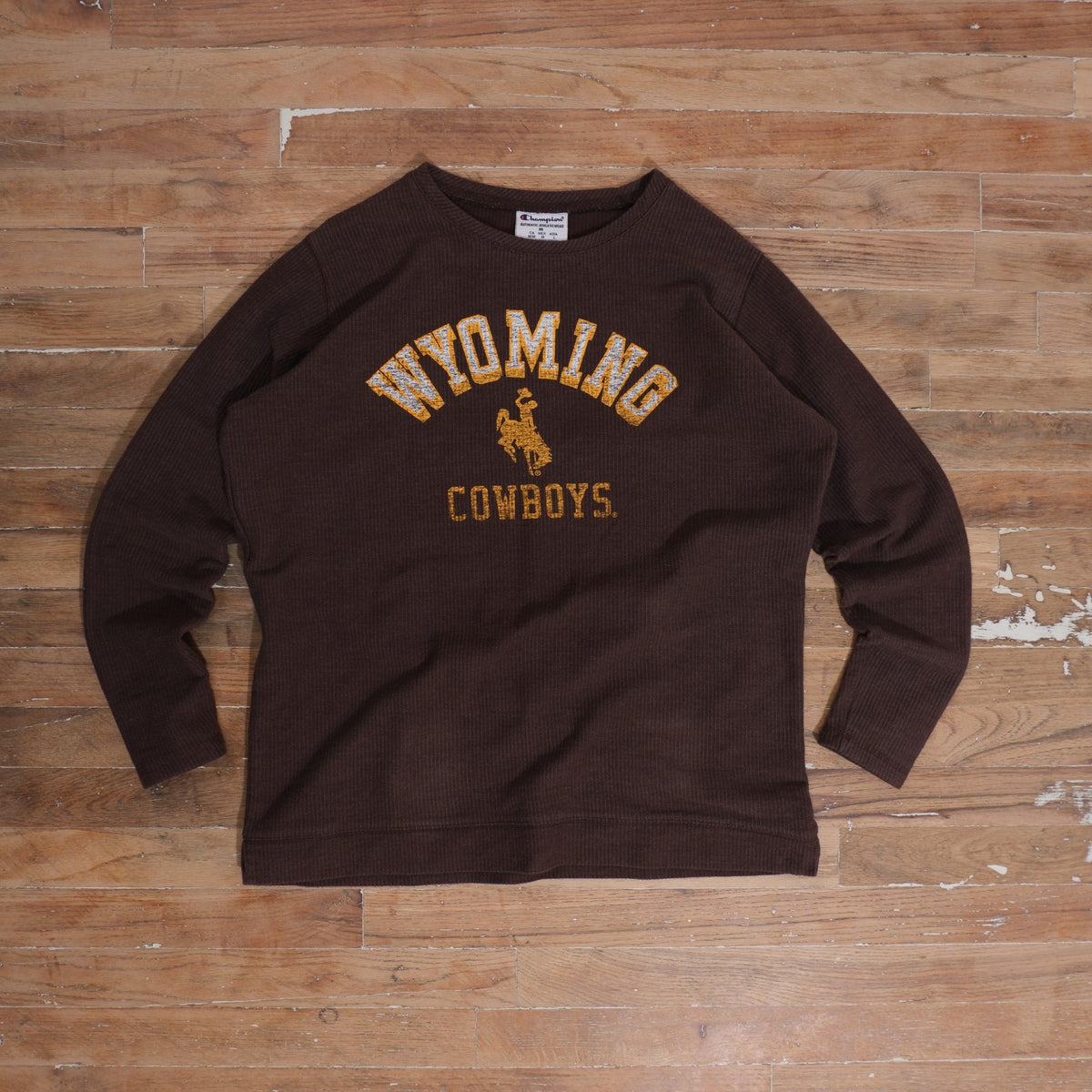 Mid-2000s brown / gold / white Champion Wyoming Cowboys Brown Waffle Knit Thermal Long Sleeve photographed flat on wood floor