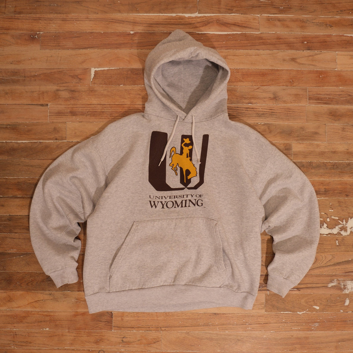 1990s heather gray / brown / gold University of Wyoming Steamboat Graphic Gray Hoodie photographed flat on wood floor