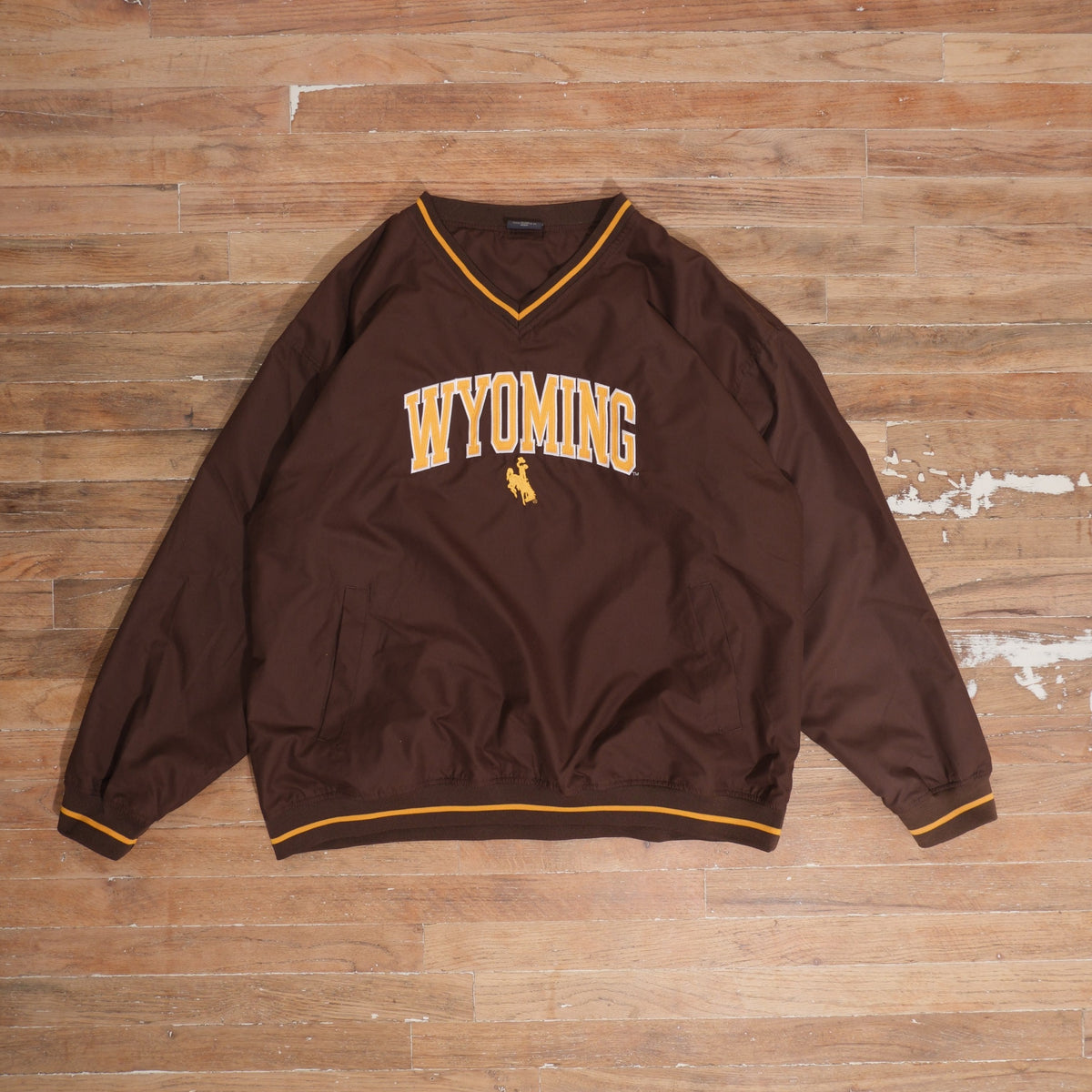 Y2K Wyoming Cowboys brown / gold windbreaker wyoming cowboys brown arched logo v-neck windbreaker front flat lay