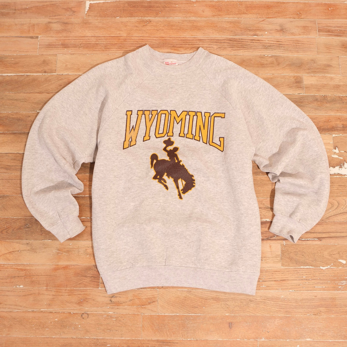 Heather gray 1990s Wyoming Cowboys crewneck with arched gold Wyoming lettering and brown Steamboat bucking horse
