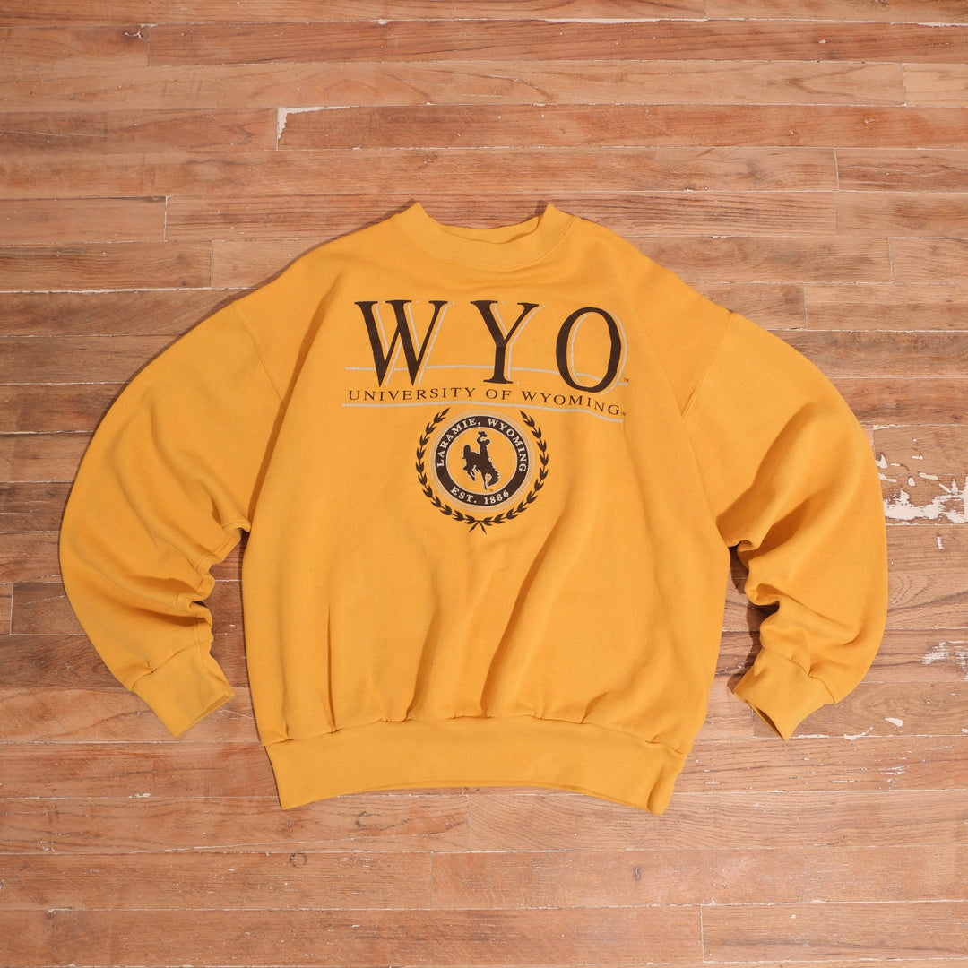 Faded gold Jansport Wyoming Cowboys crewneck with oversized WYO graphic and circular bucking horse emblem