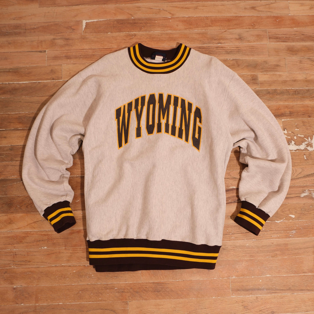 1980s heather gray Wyoming Cowboys heavyweight reverse weave crewneck with arched Wyoming graphic and striped brown gold ribbing